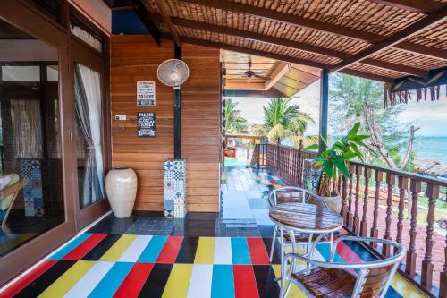 峇都丁宜失乐园度假酒店的一个带椅子的门廊和色彩缤纷的地板