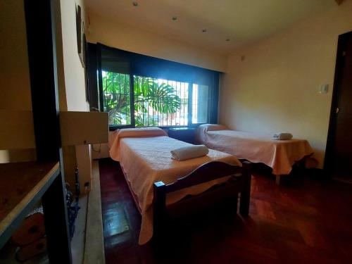 萨尔塔COYA HOSTEL的客房设有两张床和窗户。
