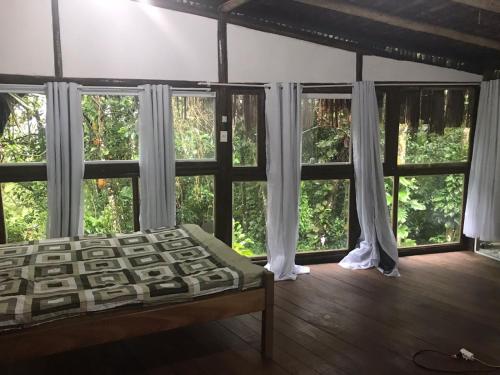 阿布拉奥Bosque dos Esquilos的一间带大窗户的卧室和一张位于客房内的床