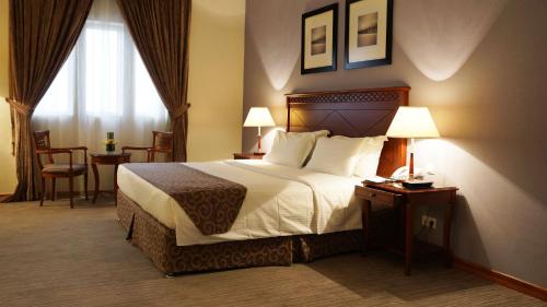 利雅德行政酒店 - 奥拉亚的酒店客房带一张床、一张桌子和椅子