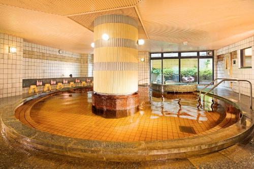 金泽金泽白鸟路山乐酒店的大型客房,位于一座建筑中,设有大型水池
