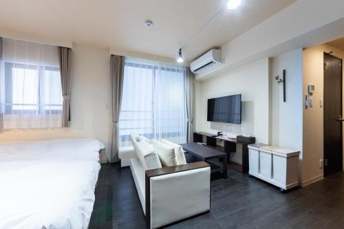 东京VACATION INN HEIWAJIMA 1 - Vacation STAY 10876的酒店客房设有一张床、一张书桌和一台电视机。