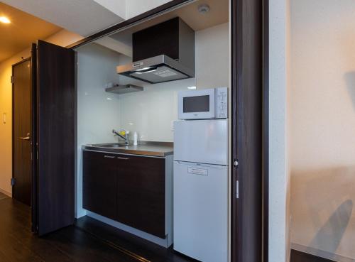 东京VACATION INN HEIWAJIMA 1 - Vacation STAY 10876的小厨房配有冰箱和微波炉。