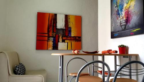 那不勒斯Vima's home的一张桌子、两把椅子和墙上的一幅画