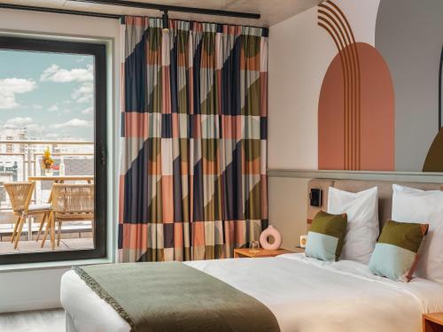 巴黎La Belle Ville的酒店客房设有一张床和一个大窗户