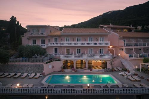帕莱欧卡斯提撒奥德修斯酒店的一座大房子,前面设有一个游泳池