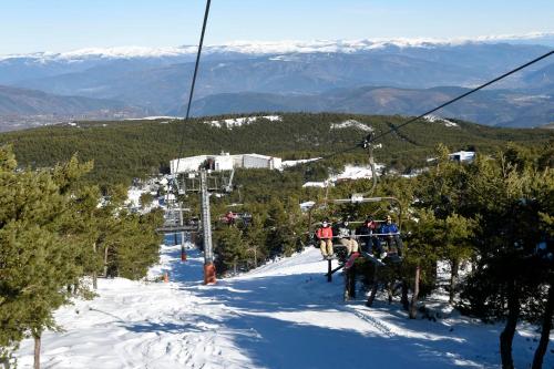 阿波夫拉德特里韦斯Estación de Montaña Manzaneda的一群人在雪覆盖的斜坡上乘滑雪缆车