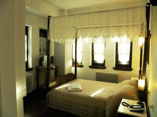 马克里尼撒佩特里诺酒店的一间卧室设有一张床和两个窗户。