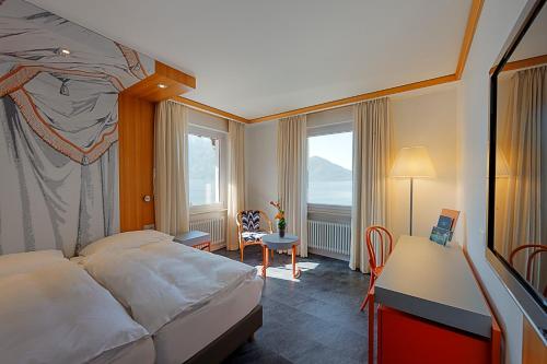 阿斯科纳Albergo Carcani by Ketty & Tommy的酒店客房设有一张床、一张书桌和窗户。
