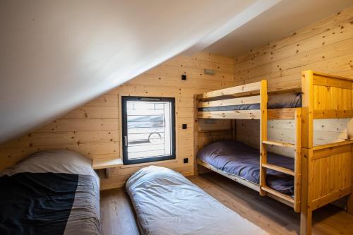 莱索尔Chalet Le Loup Blanc的小木屋设有两张双层床,配有窗户
