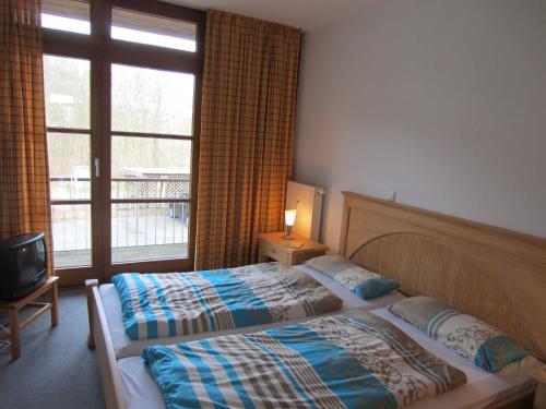 维滕贝克Ferienwohnung Sonnenwiese的酒店客房设有两张床和窗户。