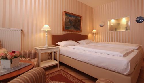 奥斯赛拜-屈隆斯博恩Ferienwohnung Antonia的卧室配有一张白色大床和一把椅子