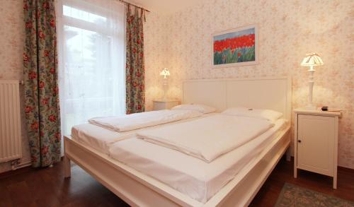 奥斯赛拜-屈隆斯博恩Ferienwohnung Muschelsucher的卧室配有一张大白色床和窗户