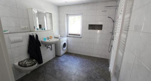 奥斯赛拜-屈隆斯博恩Ferienwohnung Iris的白色的浴室设有水槽和洗衣机。