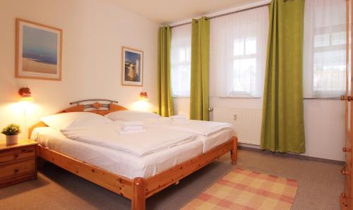 奥斯赛拜-屈隆斯博恩Ferienwohnung Parkblick Nr. 25的一间卧室设有一张大床和两个窗户。