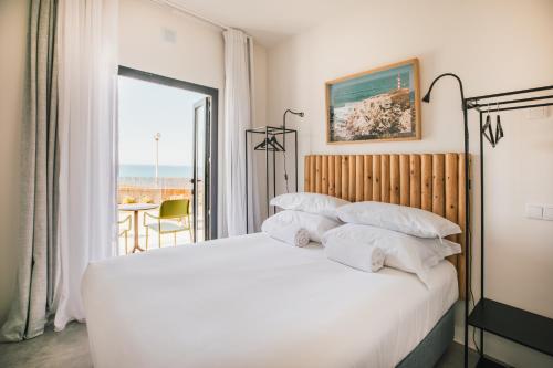 科武港MUTE Hostel Porto Covo的一间卧室设有一张床,享有海景