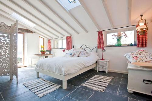 森嫩The Studio Cottage, with, Sea views, Garden, Amazing Location by beach的卧室配有白色的床和窗户。