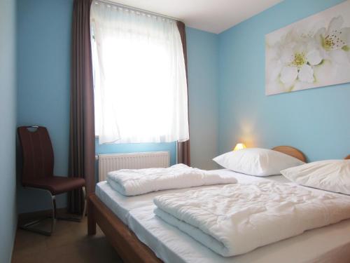 奥斯赛拜-屈隆斯博恩Ferienwohnung Hanna的一间卧室设有两张床、窗户和椅子