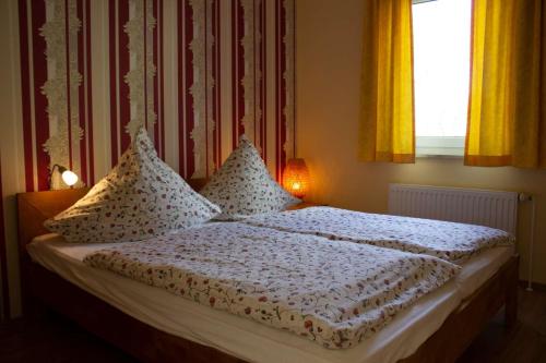 奥斯赛拜-屈隆斯博恩Ferienwohnung Elke的卧室配有带枕头的床铺和窗户。
