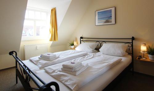 奥斯赛拜-屈隆斯博恩Ferienwohnung Birgit的一间卧室配有带白色床单和毛巾的床。