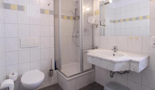 奥斯赛拜-屈隆斯博恩Ferienwohnung Parkblick Nr. 22的一间带水槽、淋浴和卫生间的浴室