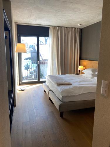 PrêlesHotel de l’Ours Preles的一间卧室设有一张床和一个大窗户