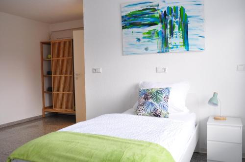 AldingenN37 -modern eingerichtete Zimmer in ruhiger Lage的卧室配有一张床,墙上挂有绘画作品