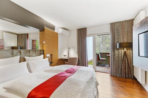 茨魏布肯法萨奈瑞兰德城堡罗曼蒂克酒店的一间卧室设有一张大床和一个滑动玻璃门