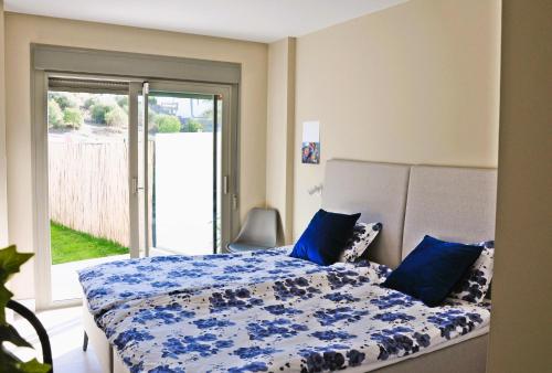马拉加Baviera Hills 1a的一间卧室配有一张带蓝色棉被的床