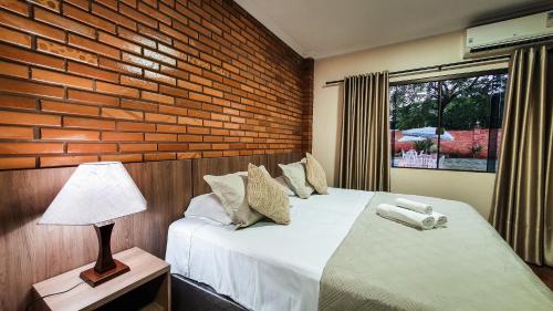 伊瓜苏Pousada Rio Das Aguas的一间卧室设有两张床和砖墙
