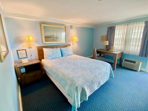 法尔茅斯The Heights Hotel的配有一张床和一张书桌的酒店客房