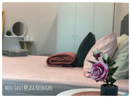 怡保Meru Oasis at Casa Kayangan Ipoh的一张带粉红色床垫和花瓶的床