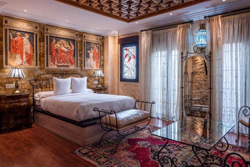 格拉纳达Casa de Reyes的一间卧室配有一张床、一把椅子和绘画作品