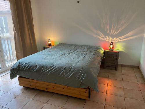 奥斯坦德Ruim zonnig appartement op 50m van strand的一间卧室配有一张床和两个带灯的床头柜