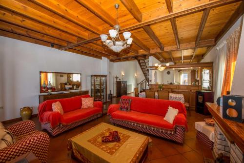 阿查拉维Frosos Beachfront Maisonette Acharavi的客厅配有红色家具和木制天花板