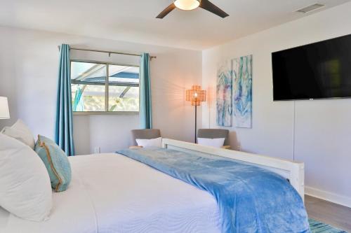 萨拉索塔Sarasota Serenity的卧室配有白色的床和平面电视。