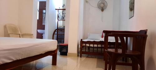 马特勒Polhena Coral Reef Resort的卧室配有一张床和一张桌子及椅子