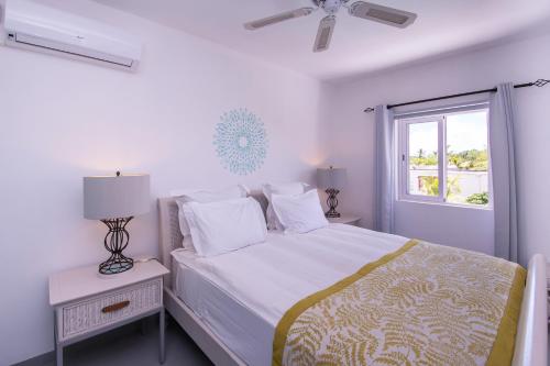 康隆尼角曼荼罗莫里斯度假屋的白色的卧室设有床和窗户