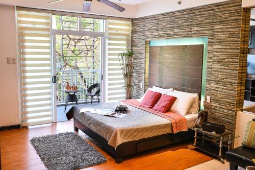 纳苏格布Pico de Loro Hamilo Coast by Beach Homes的一间卧室设有一张带砖墙的大床