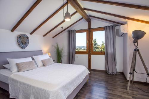 罗德岛卡利地亚Villa Kora的卧室配有白色的床和窗户。