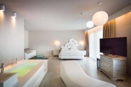 卡奥莱AQA酒店的客厅配有床和平面电视