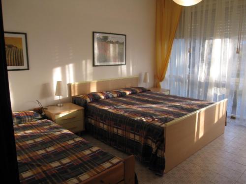 格拉多Appartamento Ritz的酒店客房设有两张床和窗户。