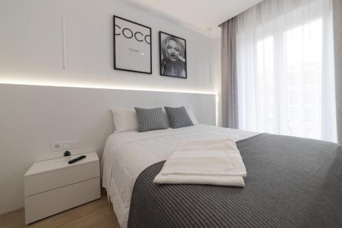 洛格罗尼奥Apartamento Logroño Avenida Ayuntamiento的白色卧室,配有带毛巾的床