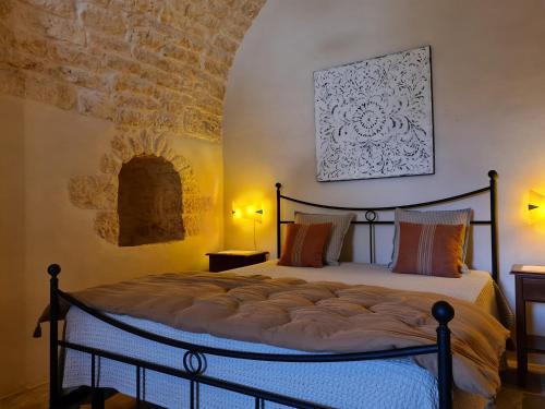 切列梅萨皮卡Masseria Montecchie的砖墙间内一间卧室,配有一张床