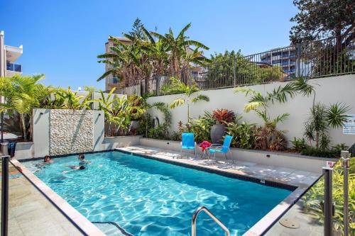 卡伦德拉Capeview Apartments - Right on Kings Beach的游泳池,有两人游泳