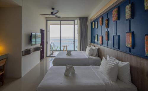 苏林海滩Norn Talay Surin Beach Phuket的酒店客房设有两张床和一个阳台。