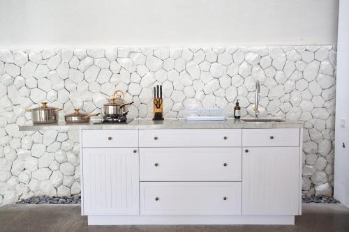 塞米亚克Calm Villa的厨房的白色柜台,设有石墙