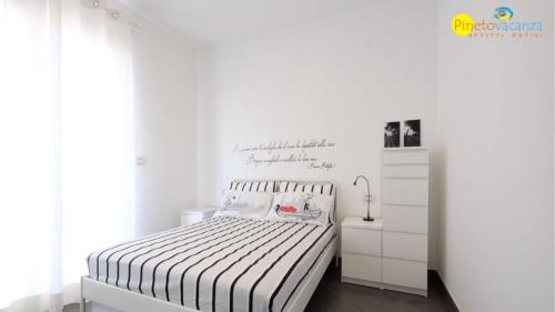 皮内托Mango 2 Pineto Vacanza的一间白色卧室,配有一张床和一个梳妆台