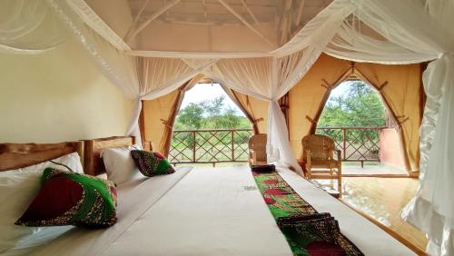 Murchison Falls National ParkMurchison Falls Bamboo Village的帐篷内一间卧室,配有一张床