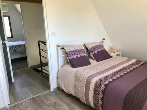 多尔多尼河畔博利厄Villa La Baronne-Hauteurs de Beaulieu-sur-Dordogne的一间卧室配有一张带紫色床单和枕头的床。